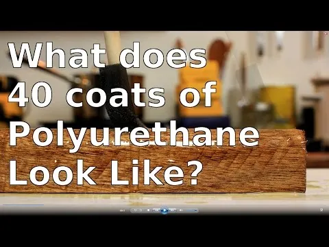 A brush applying a uniform layer of polyurethane along the grain of wood.
