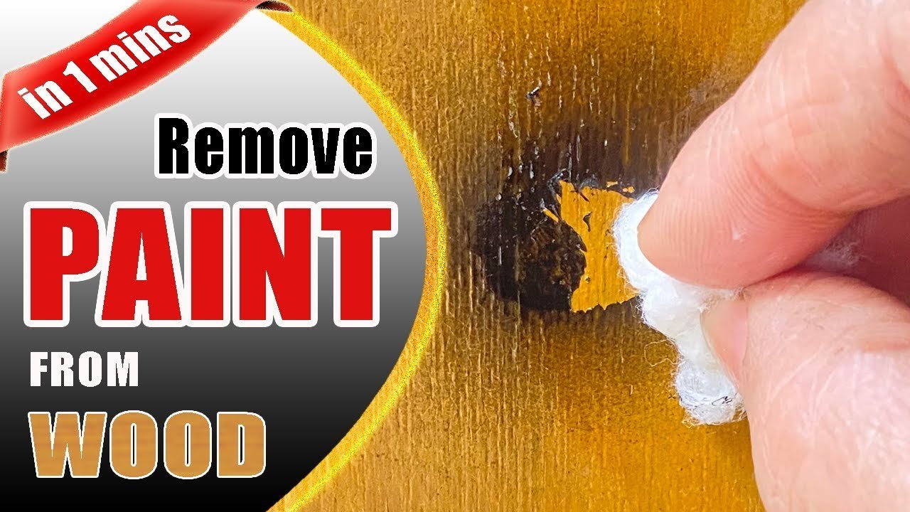 A clean cloth removing spray paint from a wooden surface in a workshop.
