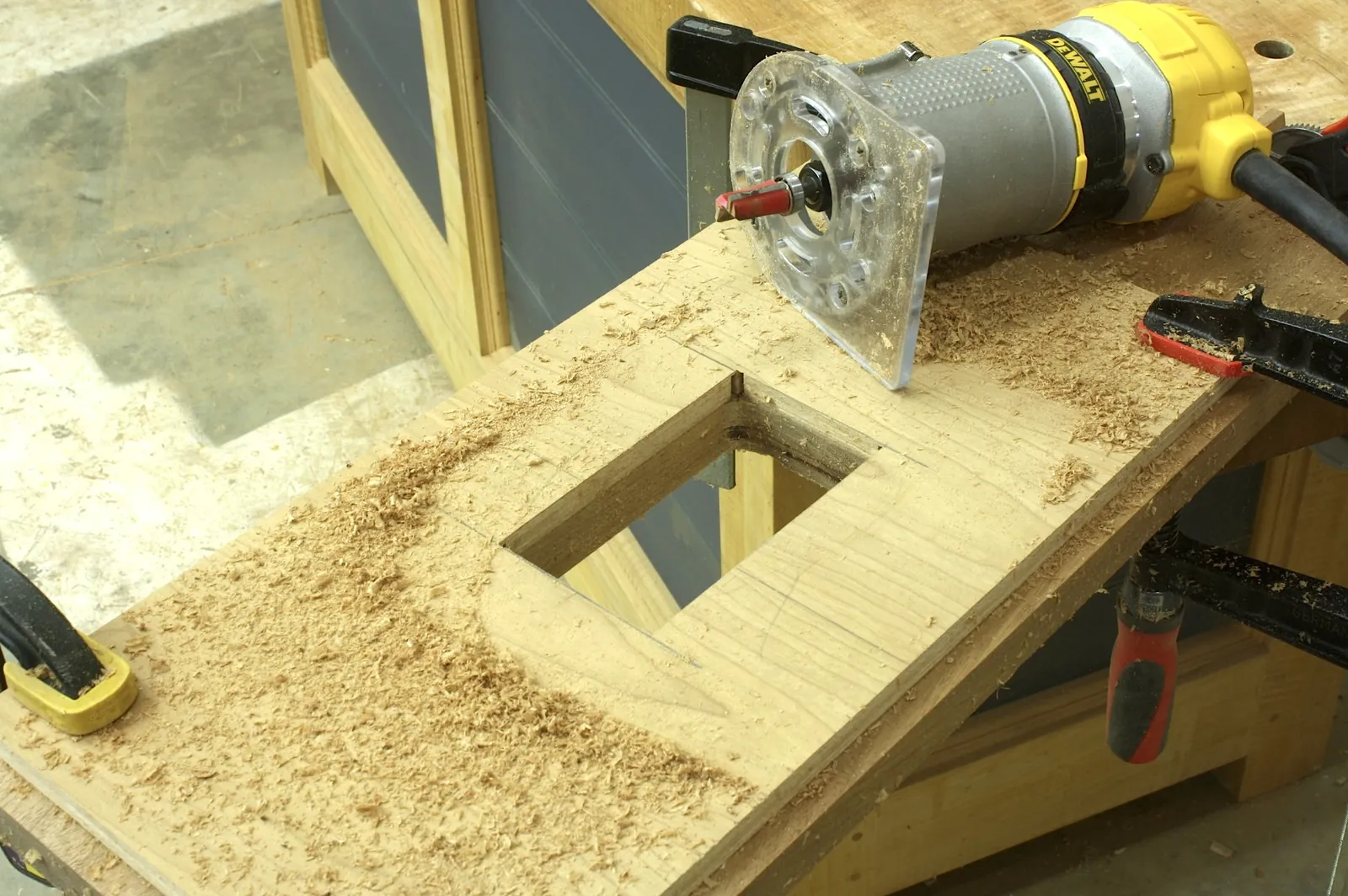 A clean square hole cut into wood with tape preventing splintering.