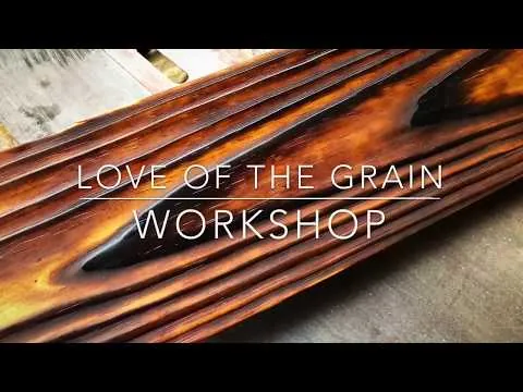 Cleaning loose soot from burnt wood with a soft nylon brush.
