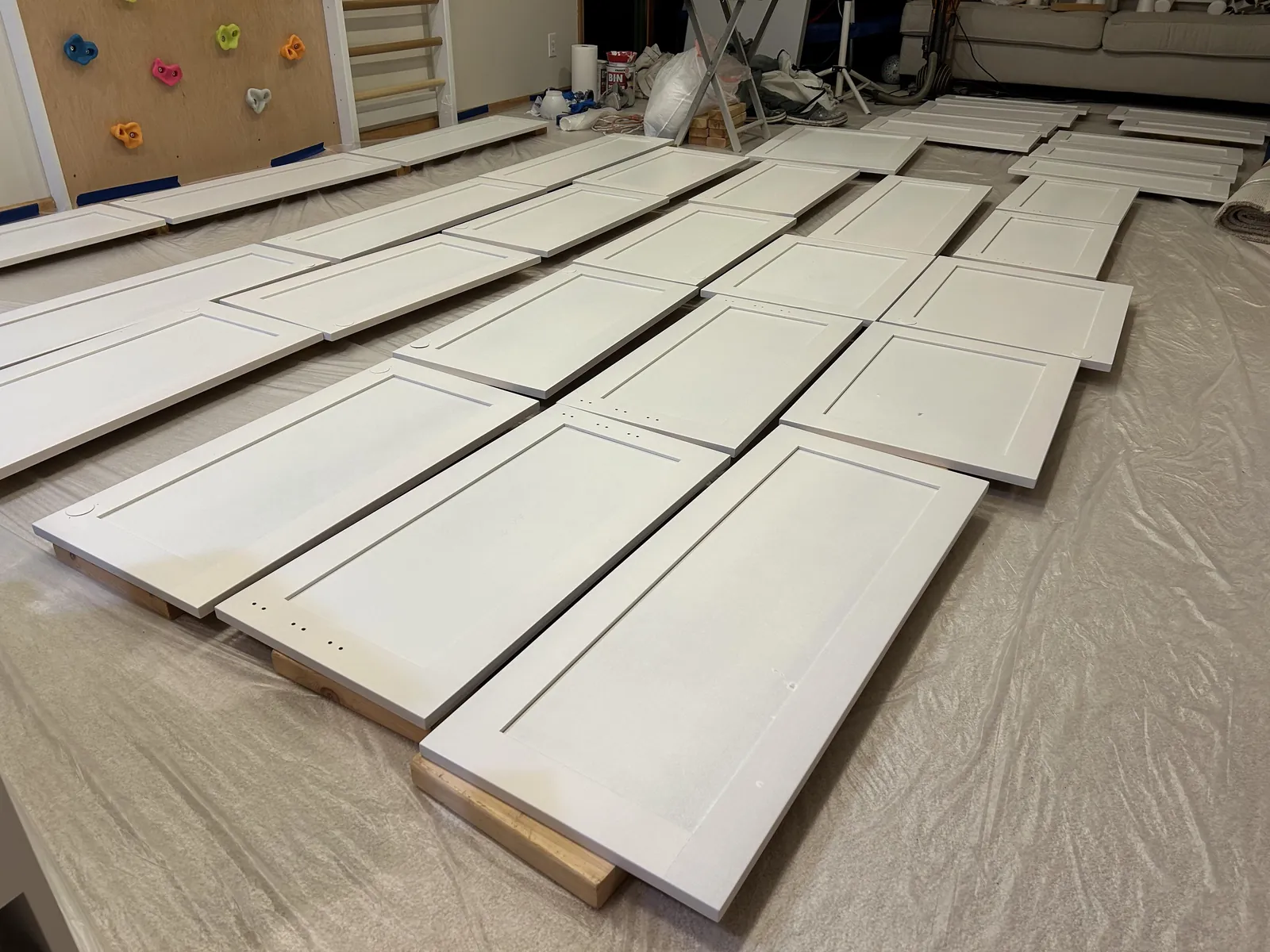 Cleaning a sanded wooden surface with a tack cloth before applying primer.