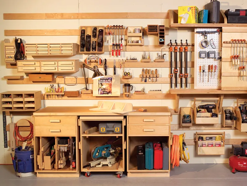 Clear storage bins and organized power tool cords hanging on a workshop wall.