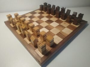 A collection of wooden chess pieces and carving tools on a workbench.