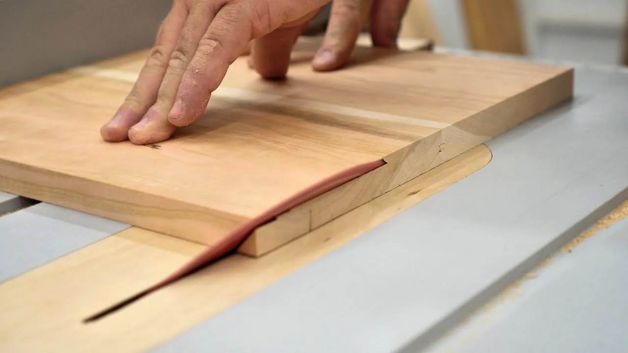 Cutting a long piece of medium-density fiberboard using a standard table saw.