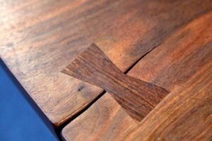 A deep crack in a rustic wooden slab shows how to stop wood splitting.