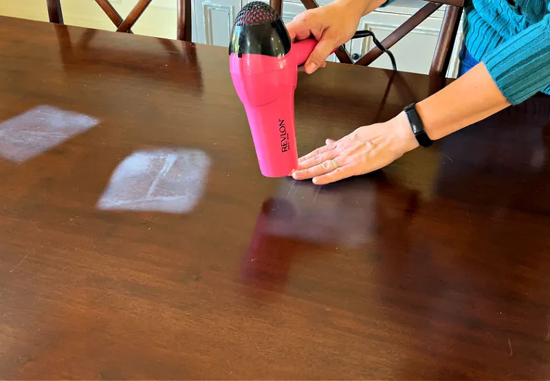 A deep scorch mark on a wooden table requiring professional repair.