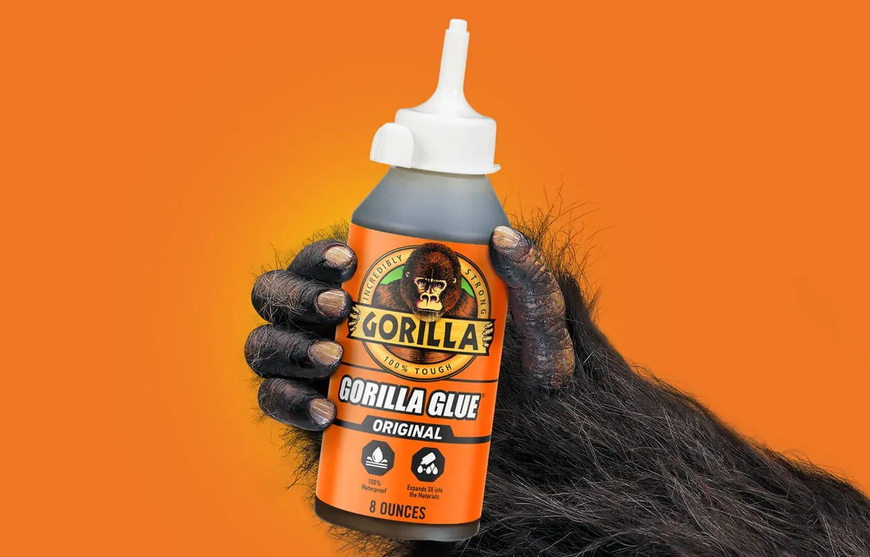 Essential tools like acetone, scrapers, and sandpaper arranged for removing glue from wood.