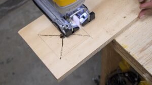 A jigsaw used to cut a precise square hole in a wood board.
