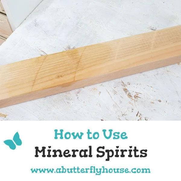 A person carefully applying mineral spirits to wood to clean the surface.