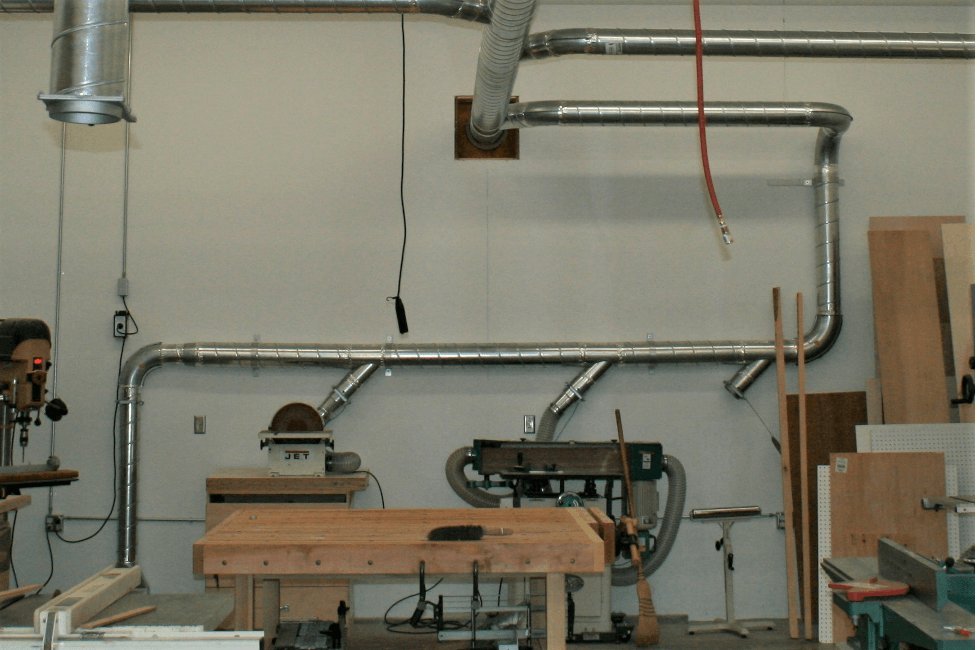 Professional dust collection system installed in a modern woodworking workshop.