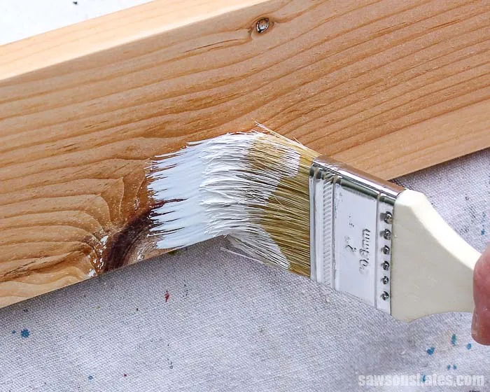 Professional painting tools and wood primer prepared for treating pine trim surfaces.