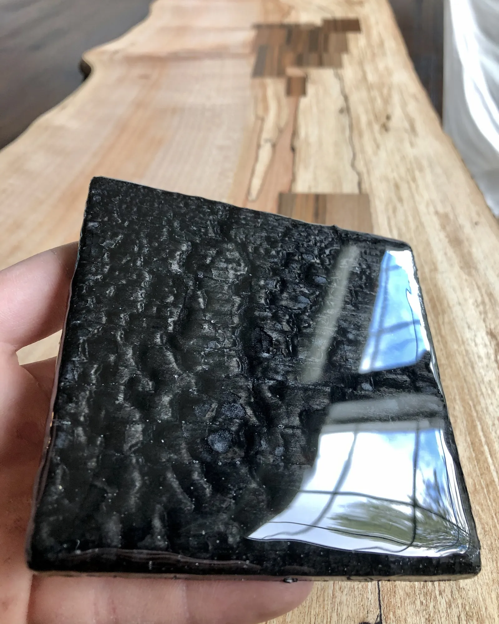 Sanding the high points of sealed charred wood for professional results.