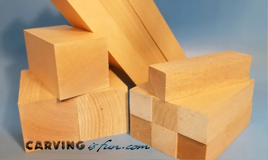 A sharp chisel rests beside a piece of wood showing rough, fuzzy carving fibers.