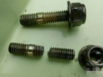 A technician inspecting a piece of stainless steel equipment for a broken screw.