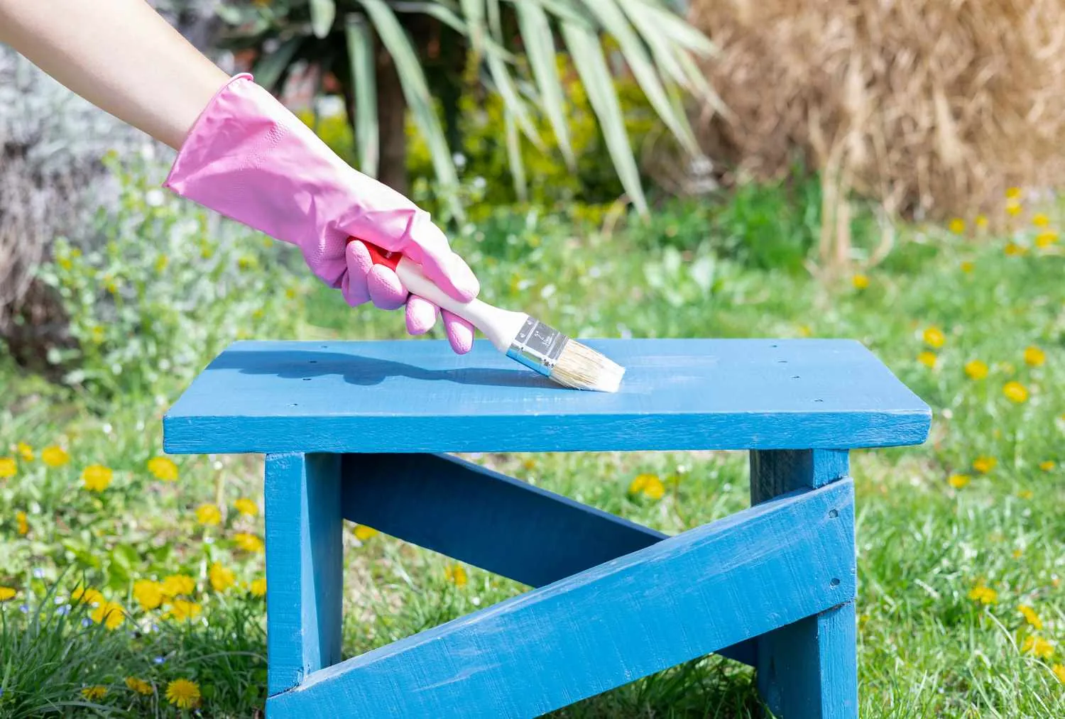 Various cans of wood sealant sitting on a workbench for protecting painted surfaces.